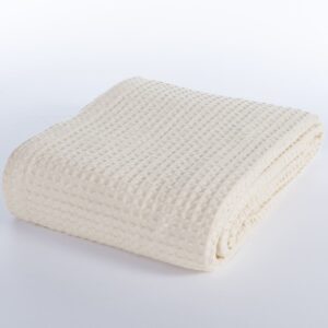 Beige 100% cotton pique blanket with a textured waffle weave, folded to showcase its soft garment-washed finish and lightweight design.