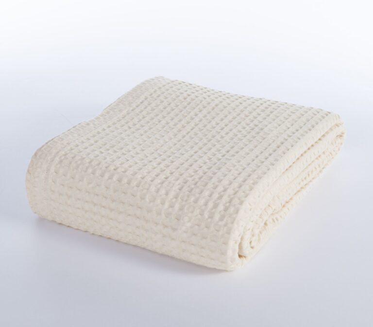 Beige 100% cotton pique blanket with a textured waffle weave, folded to showcase its soft garment-washed finish and lightweight design.
